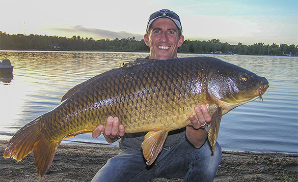 Angler holding large carp caught in Canada/