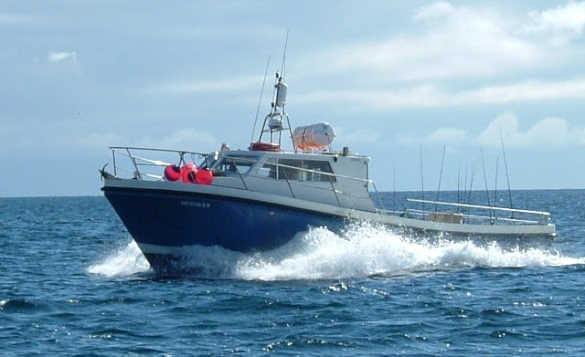 sea fishing boat travelling across open water/