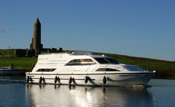 large white cruiser cruising past an island with a monument on top of a grassed hill/