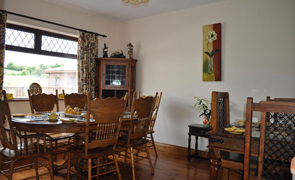 dining room with dark pine table and chairs set for breakfast/