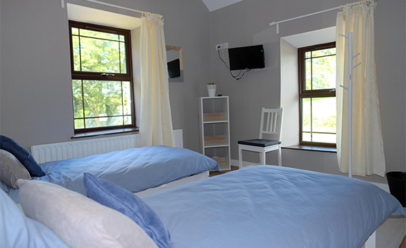 Bedroom with two single beds at Garadice View Farmhouse/