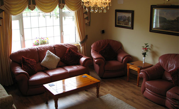 Living room with brown leather three piece suites around a coffee table/