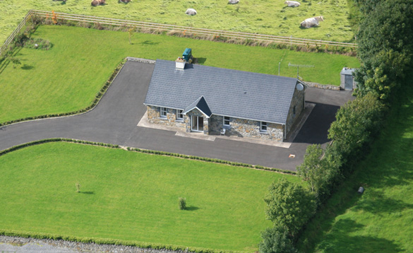 Aerial view of a stone cottage with lawn garden/