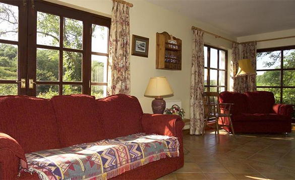 living room with tiled floor, French doors and red sofas with patterned blanket/