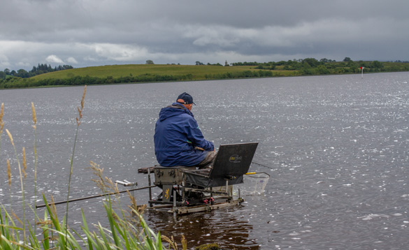 Angler sitting on a fishing stand on a lake in Ireland/
