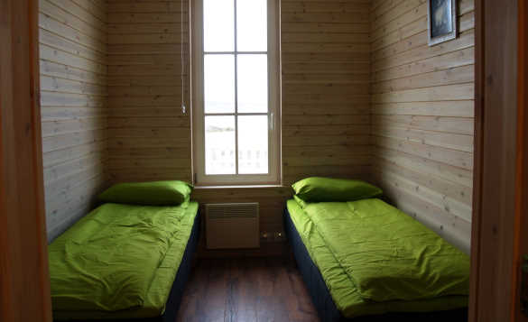 Pine clad bedroom at Vikran Fishing Centre with two single beds/