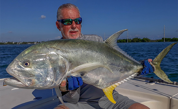 Angler sat on a boat holding a jack crevalle fish caught in Florida/