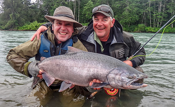 Two anglers holding a recently caught salmon on the Skeena River in Canada/