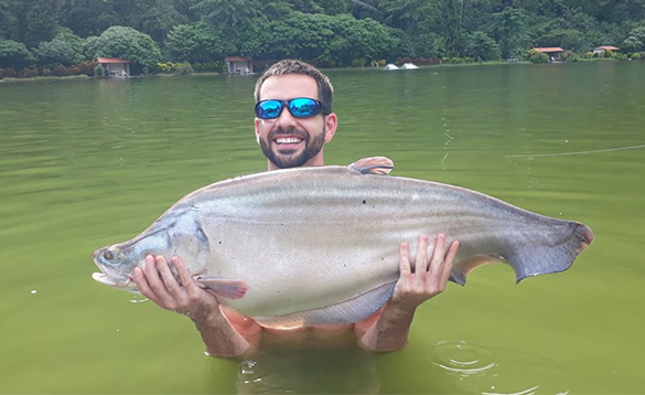 Angler holding a barramundi fish caught in Thailand/