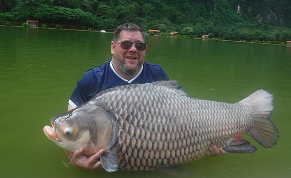 Angler holding a carp caught in Thailand/