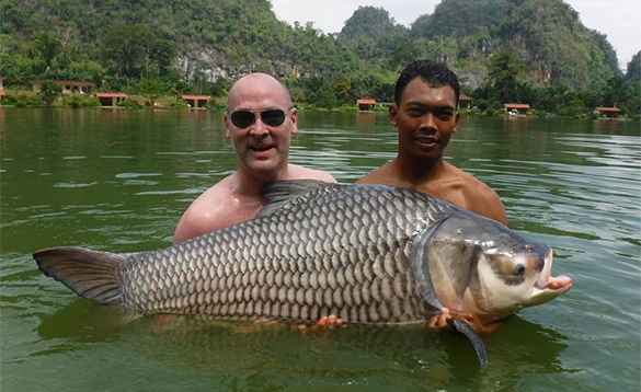 Two anglers holding a carp caught in Thailand/