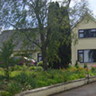 Driveway leading to yellow painted dorma bungalow