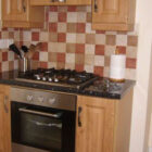 Gas hob and oven with pine units and small square tiles