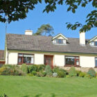 White dorma bungalow with gardens and lawn to the front