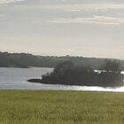 View across a lake with a tree covered island