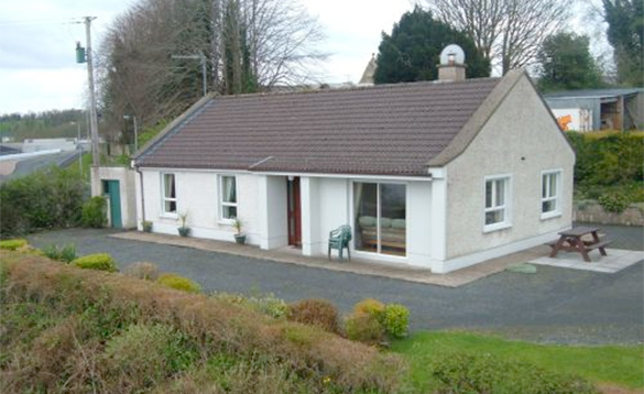 Ireland-Fishing-Holidays-CO-Cavan-lakeside-cottages-killeshandra1 White bungalow with wooden bench outside