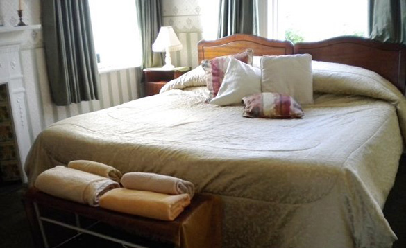 Pine double bed with cream bed linen