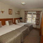 Bedroom with three single beds with fawn coloured throws