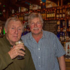 Two men in a pub in Ireland, one enjoying a pint of Guinness
