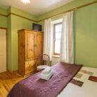 Double and single bed in green painted bedroom with pine wardrobe