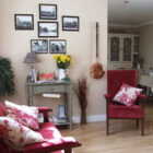 Two red chairs with flower patterned cushions in a bright sun lit room