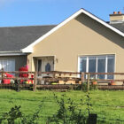 View across a field to a fawn colour painted bungalow