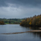View across a lake edged with autumnal trees