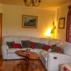 White leather corner sofa with wooden coffee table in front