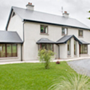 Two storey white building with front proch and sun room attached to the side
