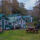 Green and white cabins set amongst trees in Alaska