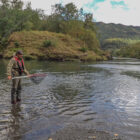 Two anglers fly fishing on a river in Alaska