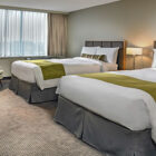 Hotel bedroom with two double beds with green throws