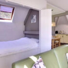 Cosy studio interior with built-in bed and compact kitchen