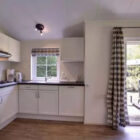 White kitchen with french doors leading to outside garden area