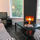 Lounge with black tiled floor and black coffee table and black and white striped sofa and two chairs