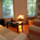 Lounge with cream settee and two chairs around a black coffee table