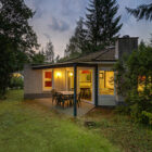 Bungalow with paved outdoor area with table and four chairs set amongst trees