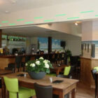 Hotel dining room with wooden tables and brown and lime green leather chairs
