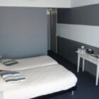 Hotel bedroom with grey painted walls and double bed with white bed linen