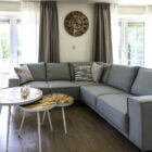 Living room with grey corner sofa and three small round coffee tables