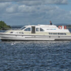 Man on a white cruiser navigating a river in Ireland