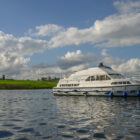 White cruiser navigating along a river