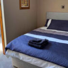 Hotel bedroom with double bed with white and blue bed linen