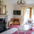 Living room with white fireplace and white settee and armchair around a coffee table