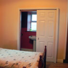 Bedroom with single bed and door leading to en-suite bathroom