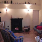 Fire buring in an open fire with rattan furniture with blue patterned cushions