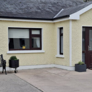 Bungalow with pale lemon painted walls and porch with brown door