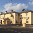 Large yellow painted pub with flower boxes at the windows
