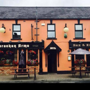 Two storey hotel with peach painted walls and black framed windows and doors