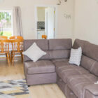 Leather sofa with white cushions pine table and six chairs